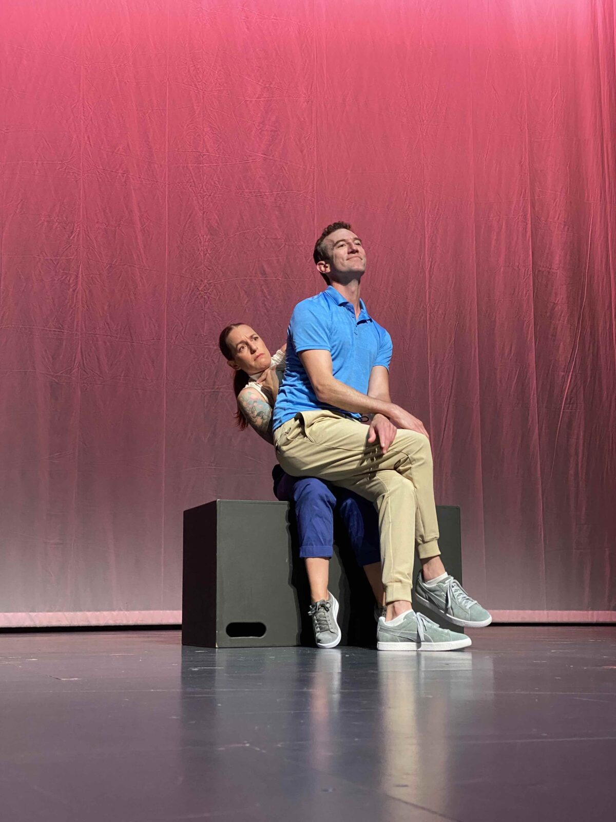 Actor sitting on actress with legs crossed during The Anxiety Piece.